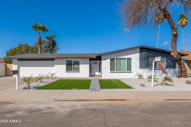 view of front of property with an attached garage, a front lawn, concrete driveway, and brick siding