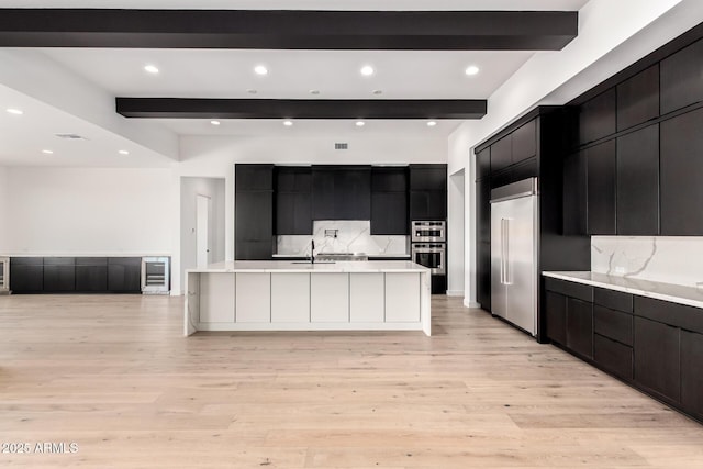 kitchen featuring light countertops, beverage cooler, modern cabinets, and dark cabinets