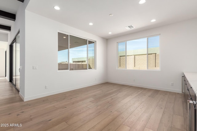 unfurnished room with visible vents, light wood-style flooring, recessed lighting, and baseboards