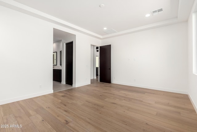 spare room featuring recessed lighting, visible vents, light wood-style flooring, and baseboards