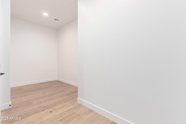 empty room with recessed lighting, visible vents, baseboards, and light wood finished floors