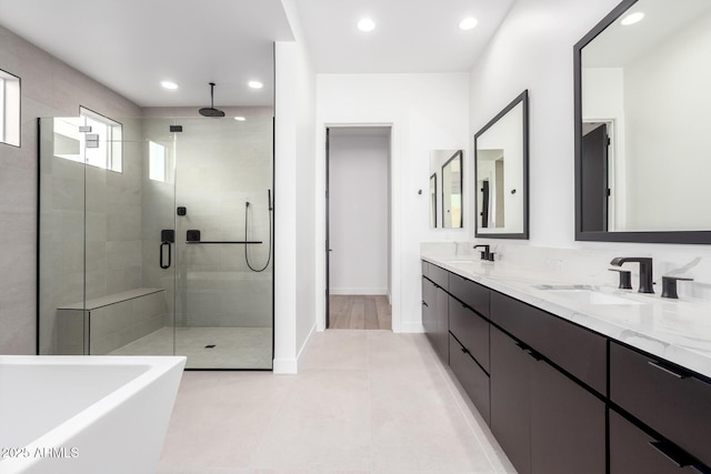 bathroom with double vanity, recessed lighting, a shower stall, and a sink