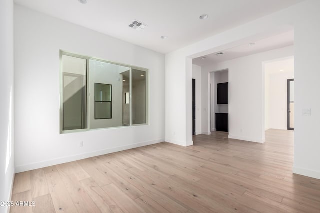 spare room with visible vents, recessed lighting, light wood-type flooring, and baseboards