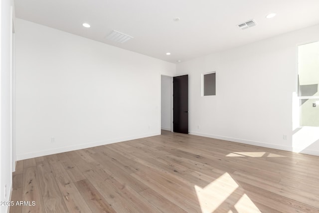 spare room with visible vents, recessed lighting, light wood-type flooring, and baseboards