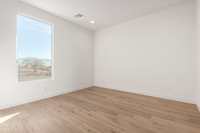 empty room featuring recessed lighting, light wood-style floors, visible vents, and baseboards