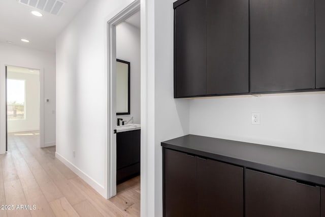 hall featuring recessed lighting, light wood-style floors, visible vents, and baseboards