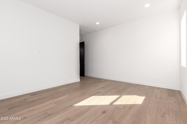 unfurnished room featuring recessed lighting, baseboards, and light wood-type flooring