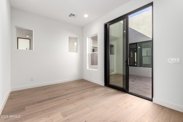 spare room with recessed lighting, wood finished floors, visible vents, and baseboards