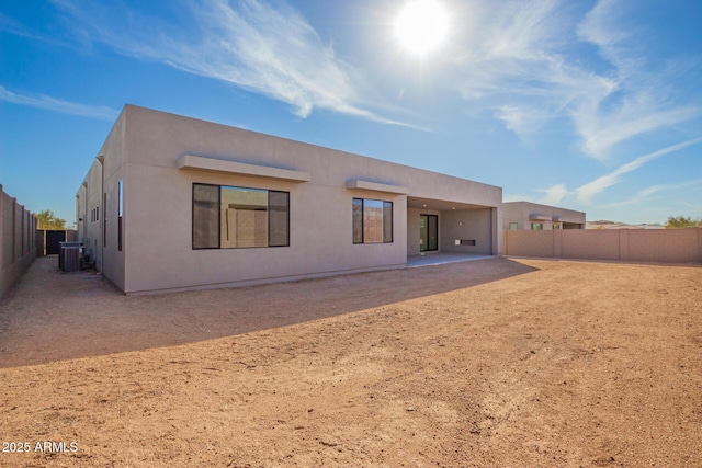 back of house featuring stucco siding, cooling unit, a fenced backyard, and a patio area