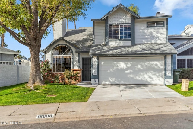 view of property with a garage and a front lawn