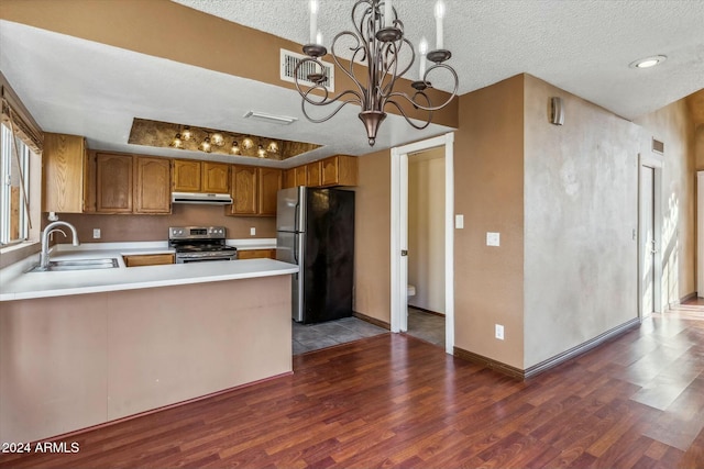 kitchen featuring a notable chandelier, sink, decorative light fixtures, kitchen peninsula, and stainless steel appliances