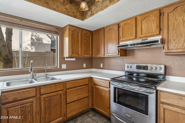 kitchen with sink, dark tile patterned floors, and stainless steel range with electric cooktop