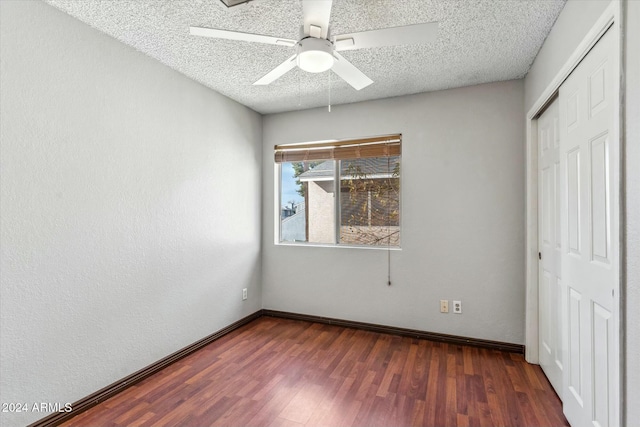 unfurnished bedroom with ceiling fan, a textured ceiling, dark hardwood / wood-style floors, and a closet