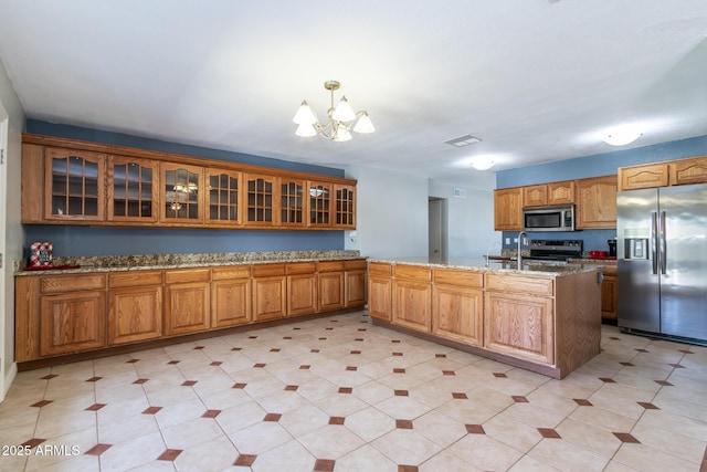 2338 E Javelina Ave, Mesa, AZ 85204 - kitchen featuring stainless steel appliances, a chandelier, glass insert cabinets, and brown cabinets