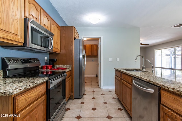 2338 E Javelina Ave, Mesa, AZ 85204 - kitchen with stainless steel appliances, light stone counters, and brown cabinetry