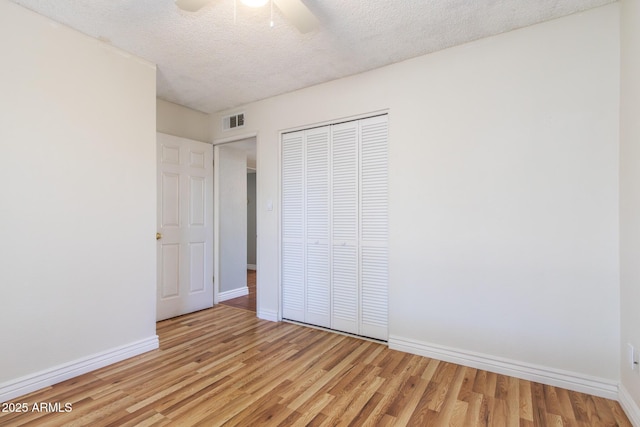 2338 E Javelina Ave, Mesa, AZ 85204 - unfurnished bedroom featuring light wood-style flooring, a textured ceiling, a closet, and a ceiling fan