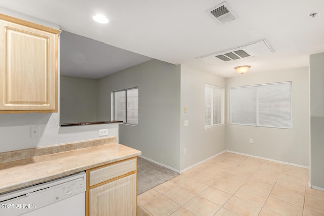 kitchen with white dishwasher, visible vents, baseboards, light countertops, and light brown cabinetry