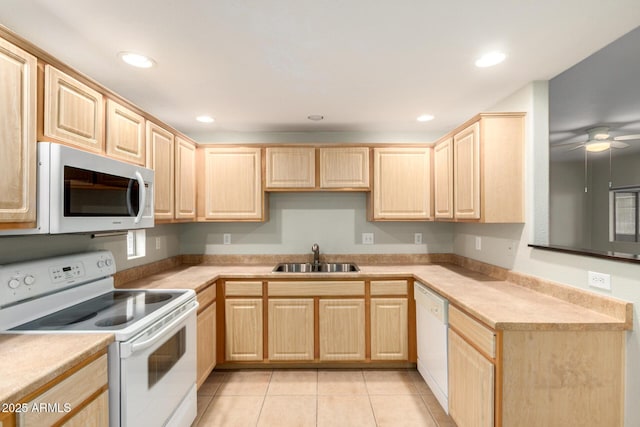 kitchen with white appliances, recessed lighting, a sink, and light brown cabinetry