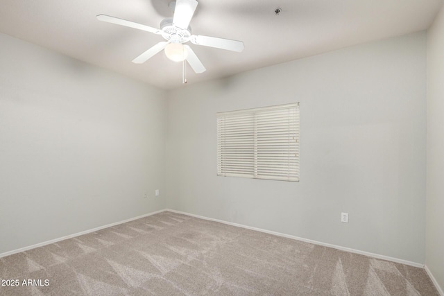 empty room featuring baseboards, a ceiling fan, and light colored carpet