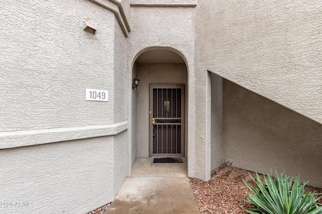 doorway to property featuring stucco siding