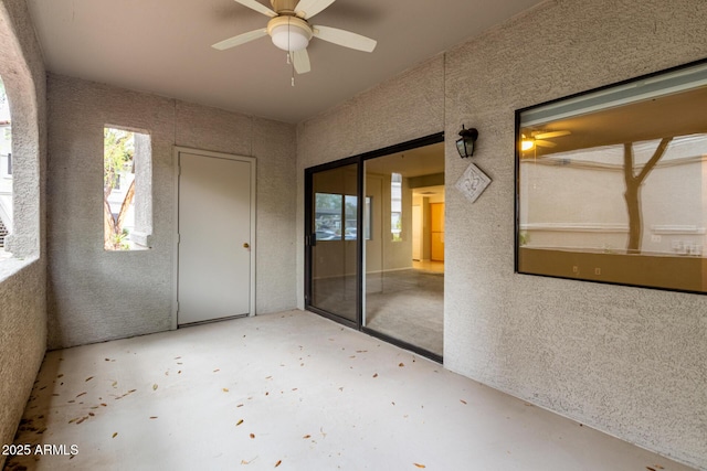 interior space featuring unfinished concrete flooring and a ceiling fan