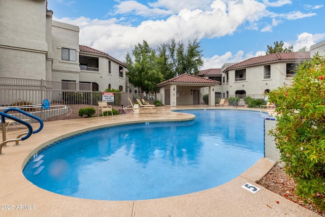 pool featuring a patio area and fence