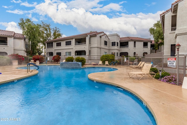 community pool featuring fence and a patio