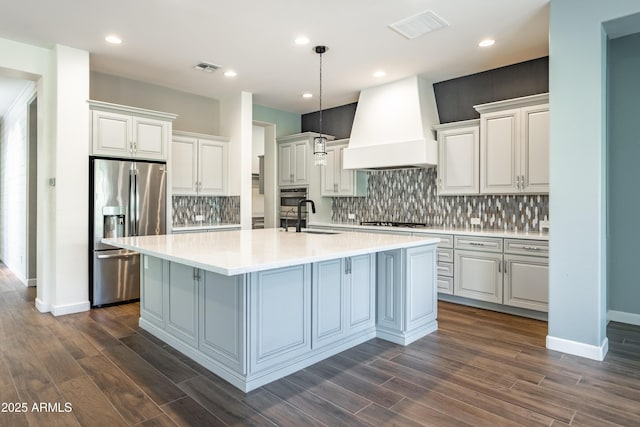 70 E Kennedia Dr, Queen Creek, AZ 85140 - kitchen with stainless steel appliances, custom range hood, a sink, a center island with sink, and light countertops