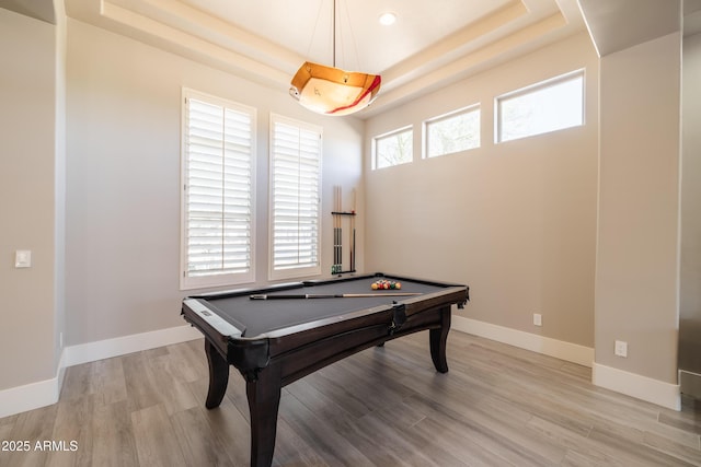 game room featuring baseboards, a raised ceiling, light wood-style flooring, and billiards