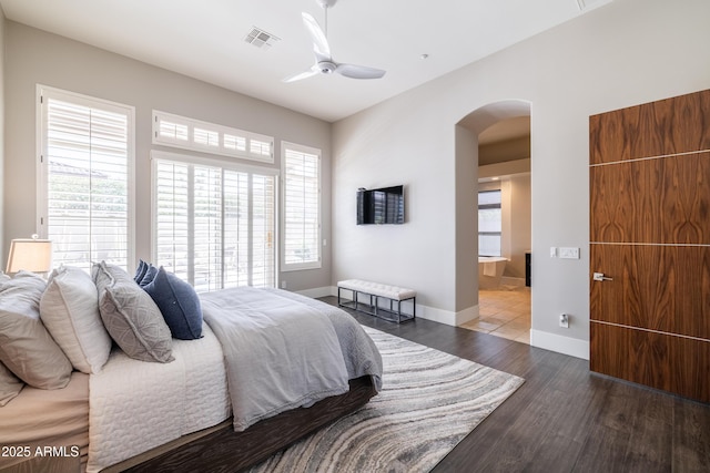 bedroom with visible vents, ceiling fan, baseboards, wood finished floors, and arched walkways