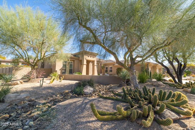 view of front facade with a fenced front yard and stucco siding