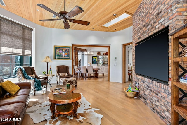 living room with a skylight, wooden ceiling, light wood-type flooring, and ceiling fan