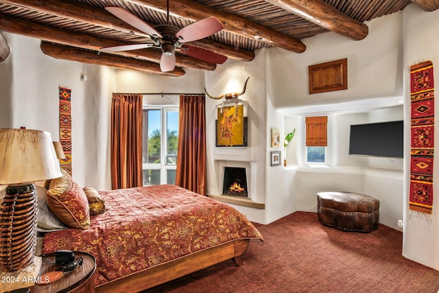 bedroom featuring carpet floors, beam ceiling, wooden ceiling, and ceiling fan