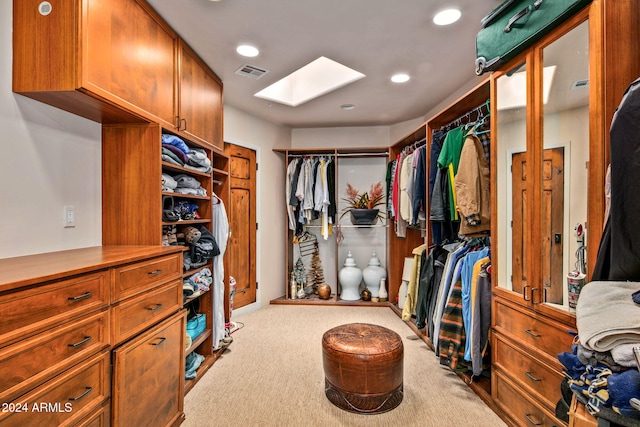 walk in closet with light carpet and a skylight