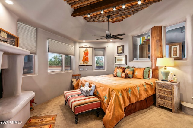 bedroom with beam ceiling, light colored carpet, and ceiling fan