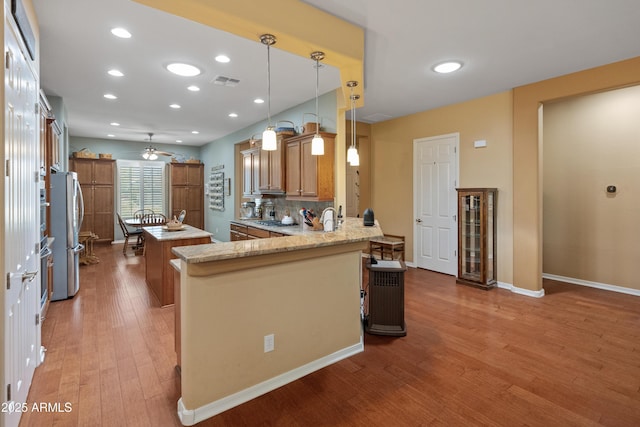 20506 N 271st Ave, Buckeye, AZ 85396 - kitchen featuring brown cabinets, stainless steel appliances, wood finished floors, wine cooler, and visible vents
