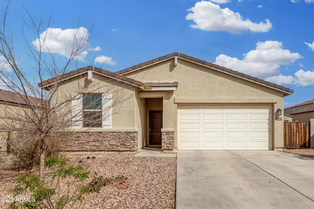 ranch-style house with driveway, stone siding, an attached garage, fence, and stucco siding