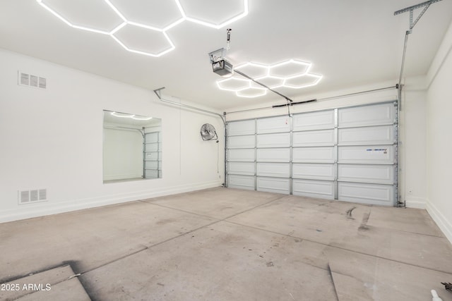 garage featuring baseboards, visible vents, and a garage door opener