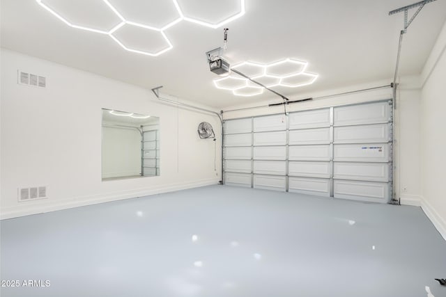 garage featuring baseboards, visible vents, and a garage door opener