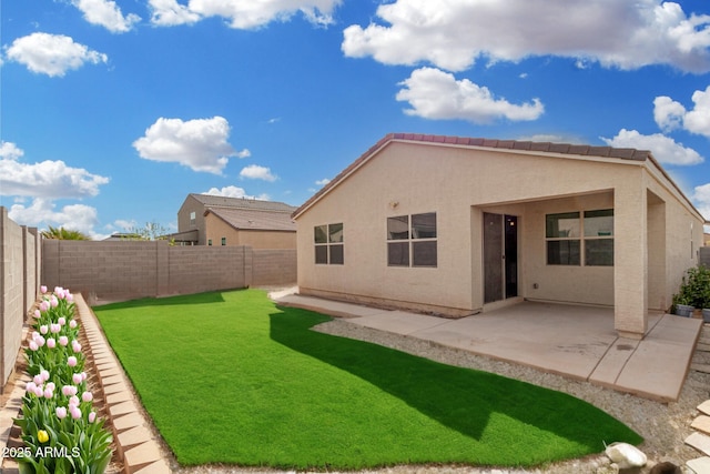 rear view of property featuring a patio area, a lawn, a fenced backyard, and stucco siding