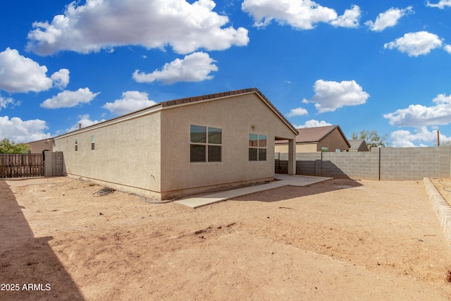 back of property featuring a fenced backyard and stucco siding