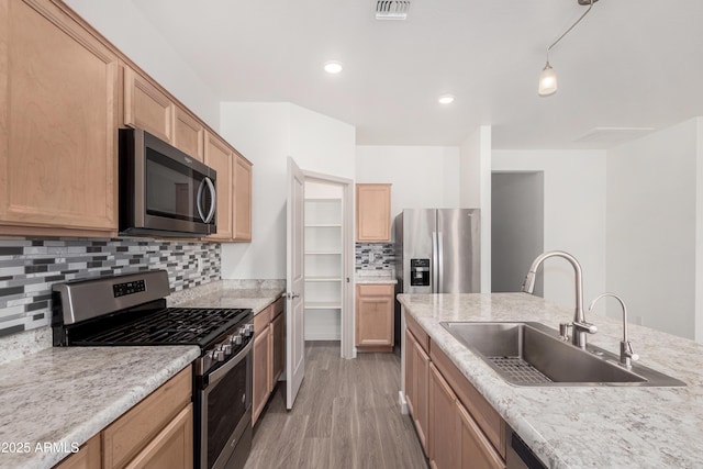 kitchen with light countertops, visible vents, appliances with stainless steel finishes, light wood-style floors, and a sink