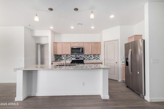 kitchen featuring a center island with sink, visible vents, decorative backsplash, appliances with stainless steel finishes, and a sink