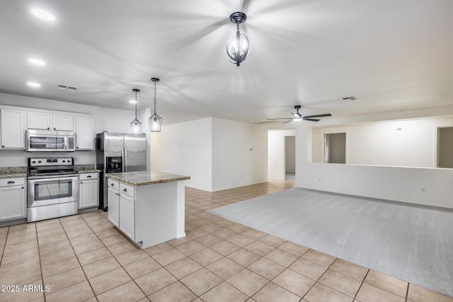 kitchen featuring light tile patterned floors, visible vents, appliances with stainless steel finishes, pendant lighting, and a center island