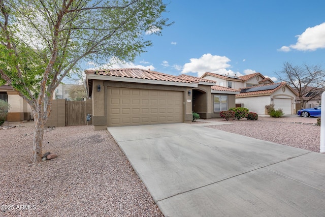 mediterranean / spanish-style house featuring stucco siding, concrete driveway, an attached garage, and a tile roof