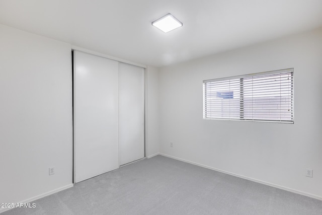 unfurnished room featuring light colored carpet and baseboards