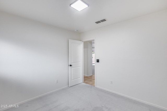 spare room featuring carpet, visible vents, and baseboards