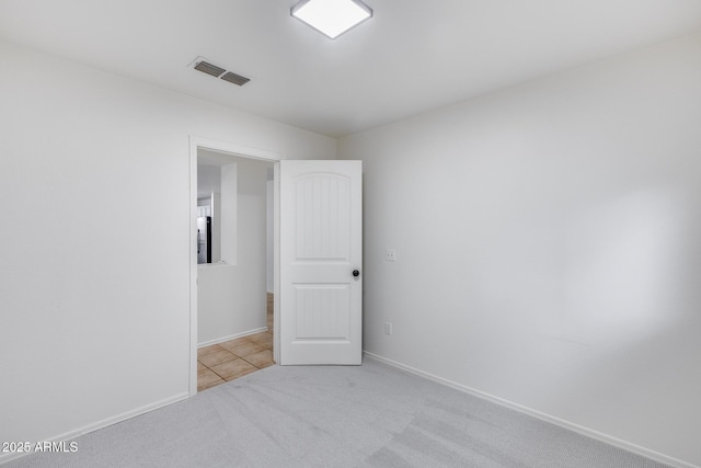 carpeted empty room featuring visible vents and baseboards