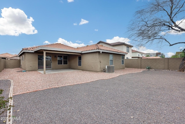 rear view of property featuring a patio, a tiled roof, a fenced backyard, and stucco siding