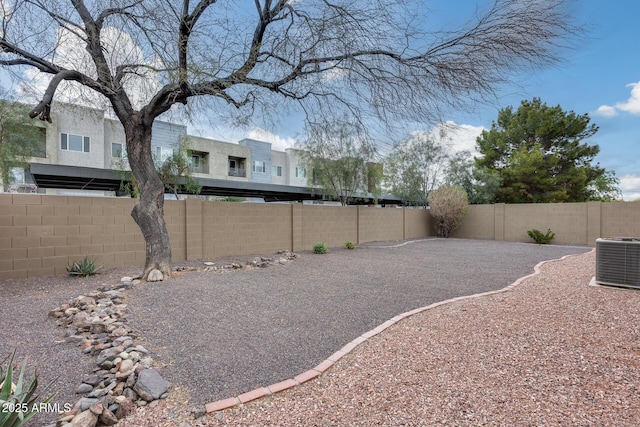 view of yard with central air condition unit and a fenced backyard